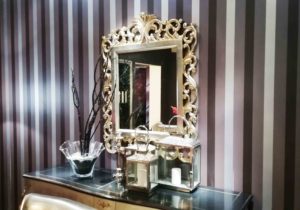 Specchio con cornice in legno e finitura argento anticata.